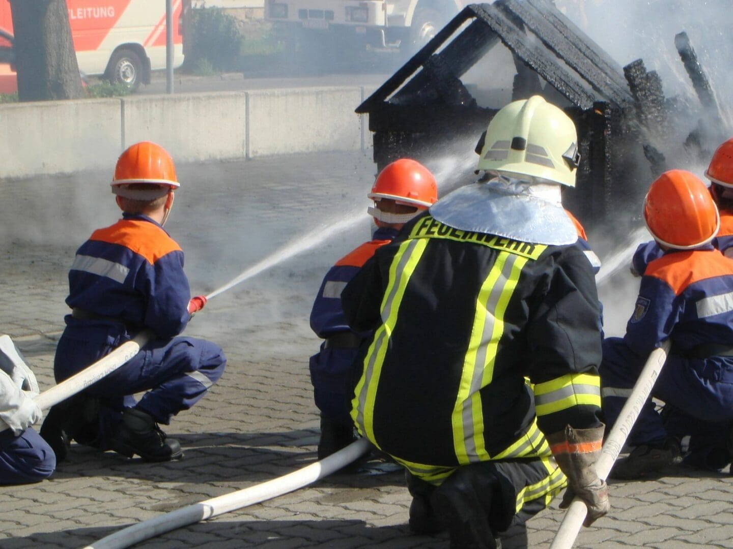 A group of people in safety gear are spraying water.