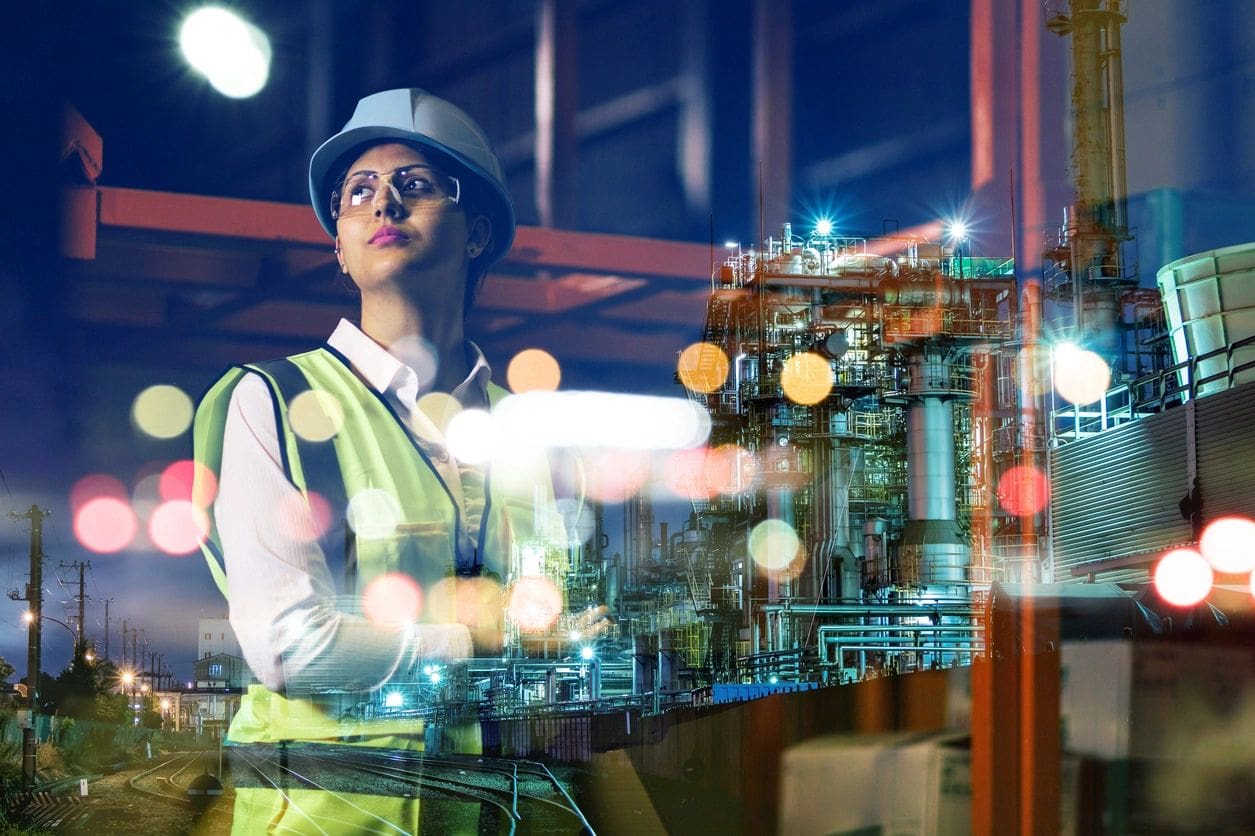 A woman in safety gear holding a tablet.