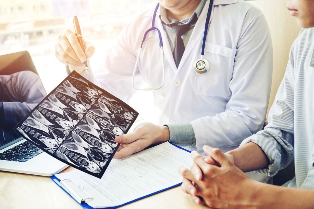 A doctor holding up an x-ray of something