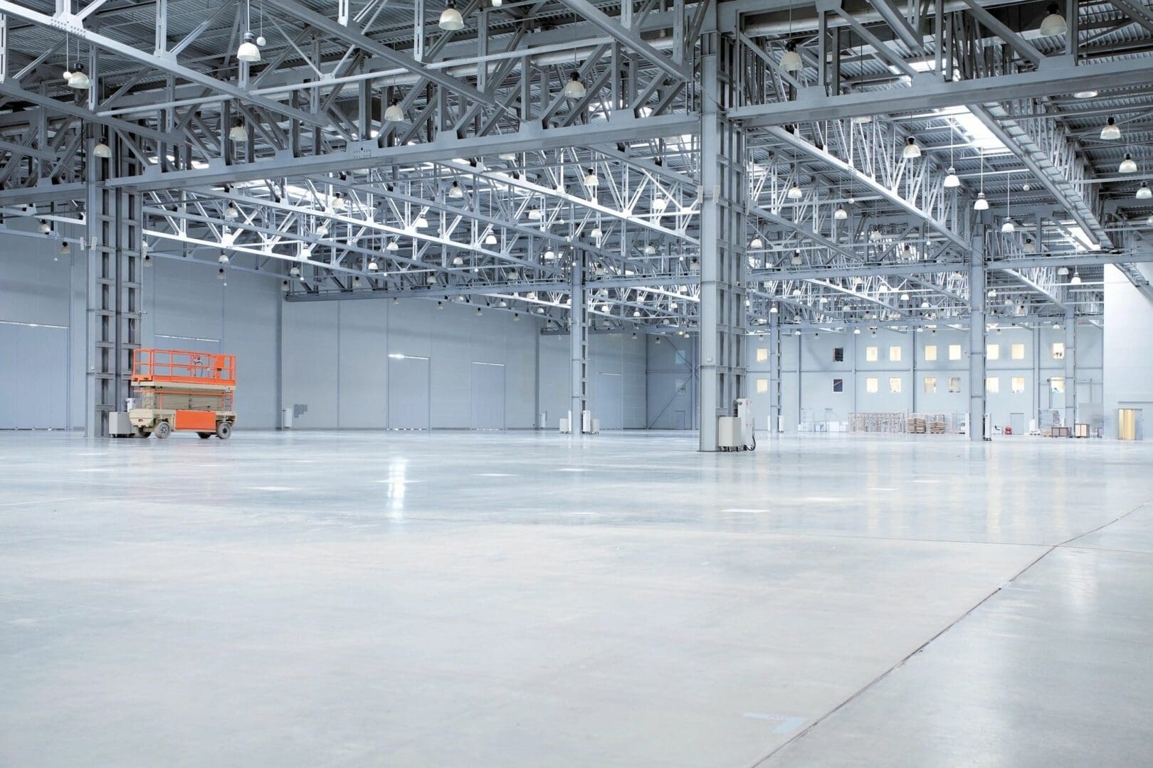 A large warehouse with many lights and a forklift.