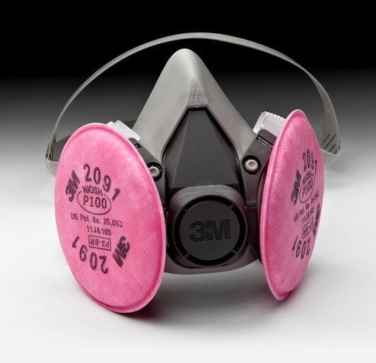 A pink respirator is sitting on the floor.